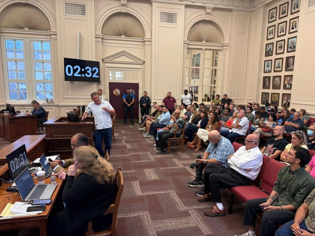 Joseph Hollmann speaks before a packed crowd during a Brownsville City Commission meeting.