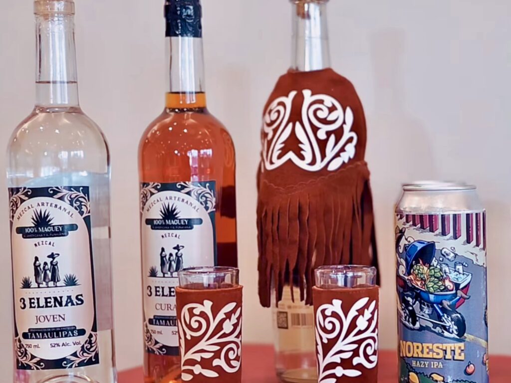 Botellas y latas de mezcal y cerveza producidos en Tamaulipas, expuestos juntos.