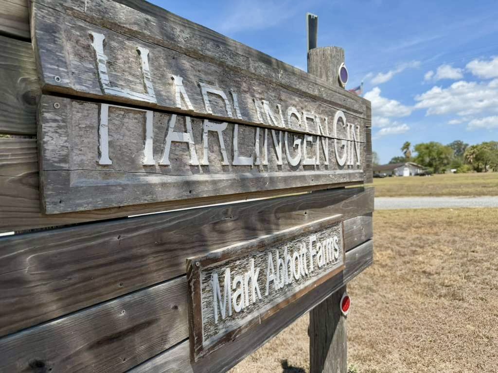 A Mark Abbott Farms sign stands beside farmland near Harlingen.