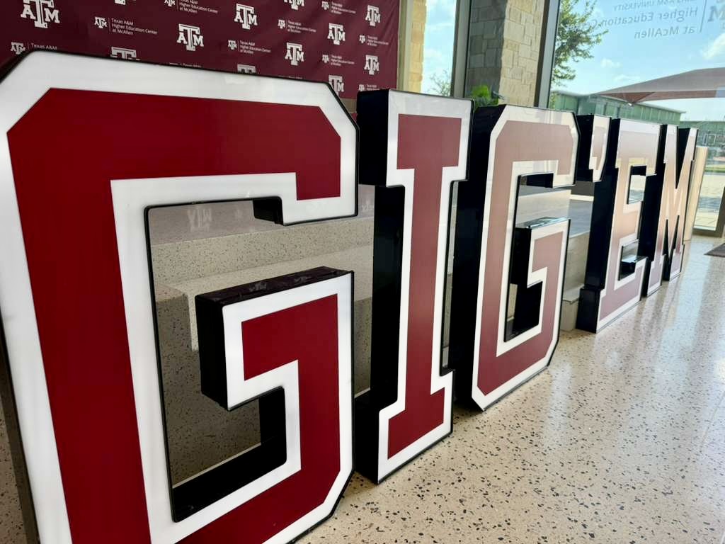 Un gran letrero con el lema «Gig ’Em» en el interior del Centro de Educación Superior de Texas A&M en McAllen.