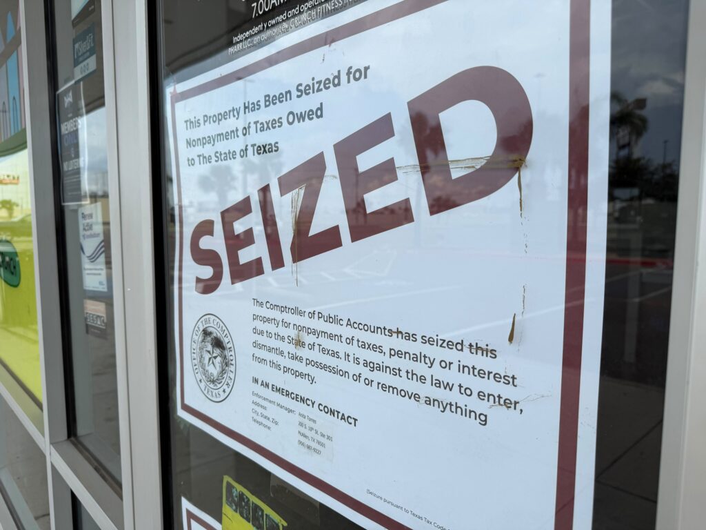 A Texas Comptroller notice reading “Seized” posted on the glass entrance of Crunch Fitness in Pharr.