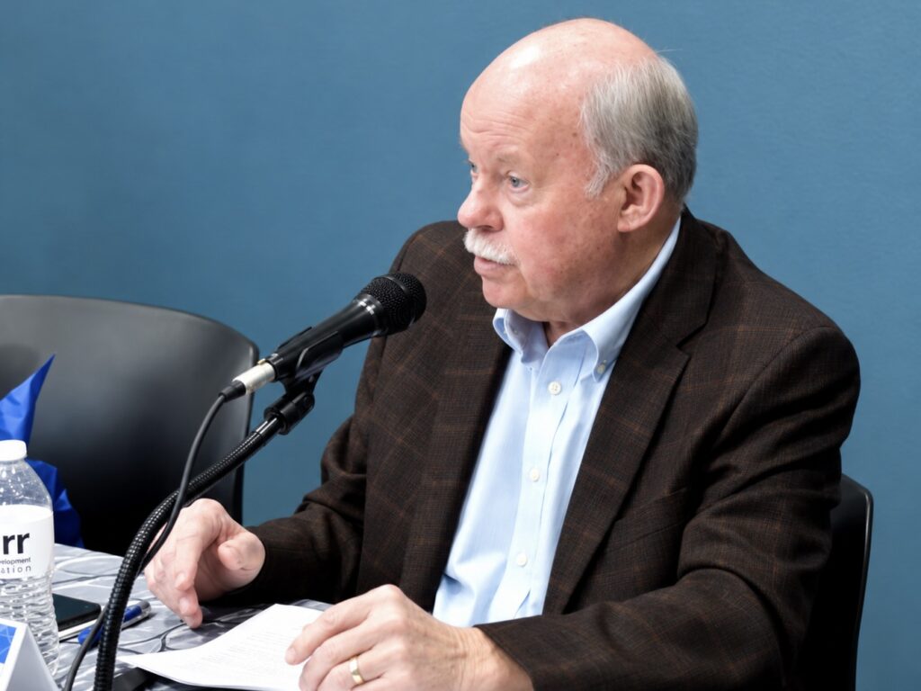 Mike Willis of the South Texas Manufacturers Association speaks into a microphone during a manufacturing workforce roundtable in Pharr.