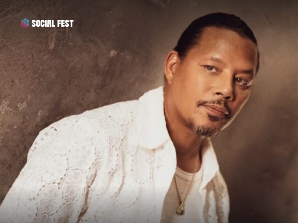 Promotional portrait of actor Terrence Howard wearing a white patterned jacket over a white shirt, with a gold necklace, against a brown background.